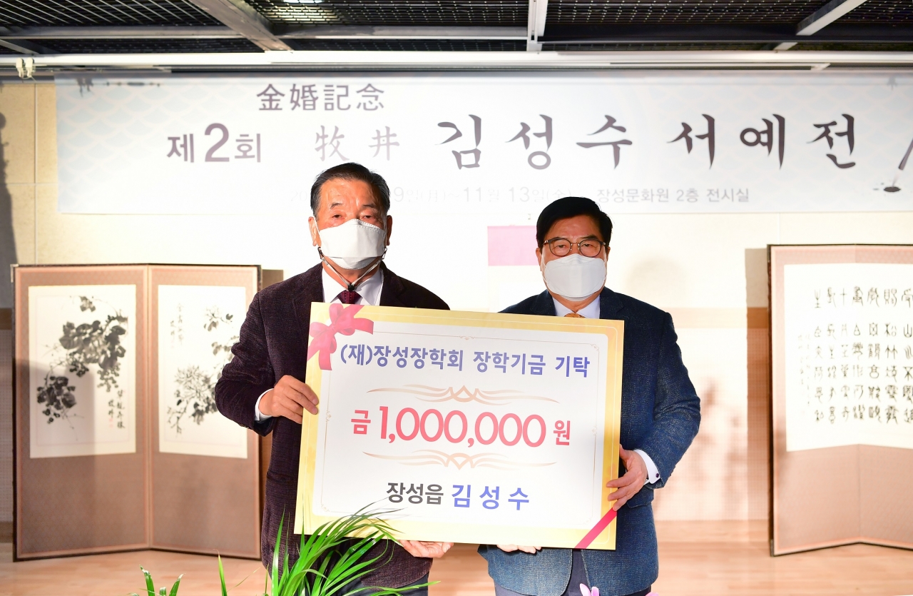 목정 김성수 선생(좌측)이 100만원의 장학금을 (재)장성장학회에 기탁했다. 사진 우측은 유두석 이사장.